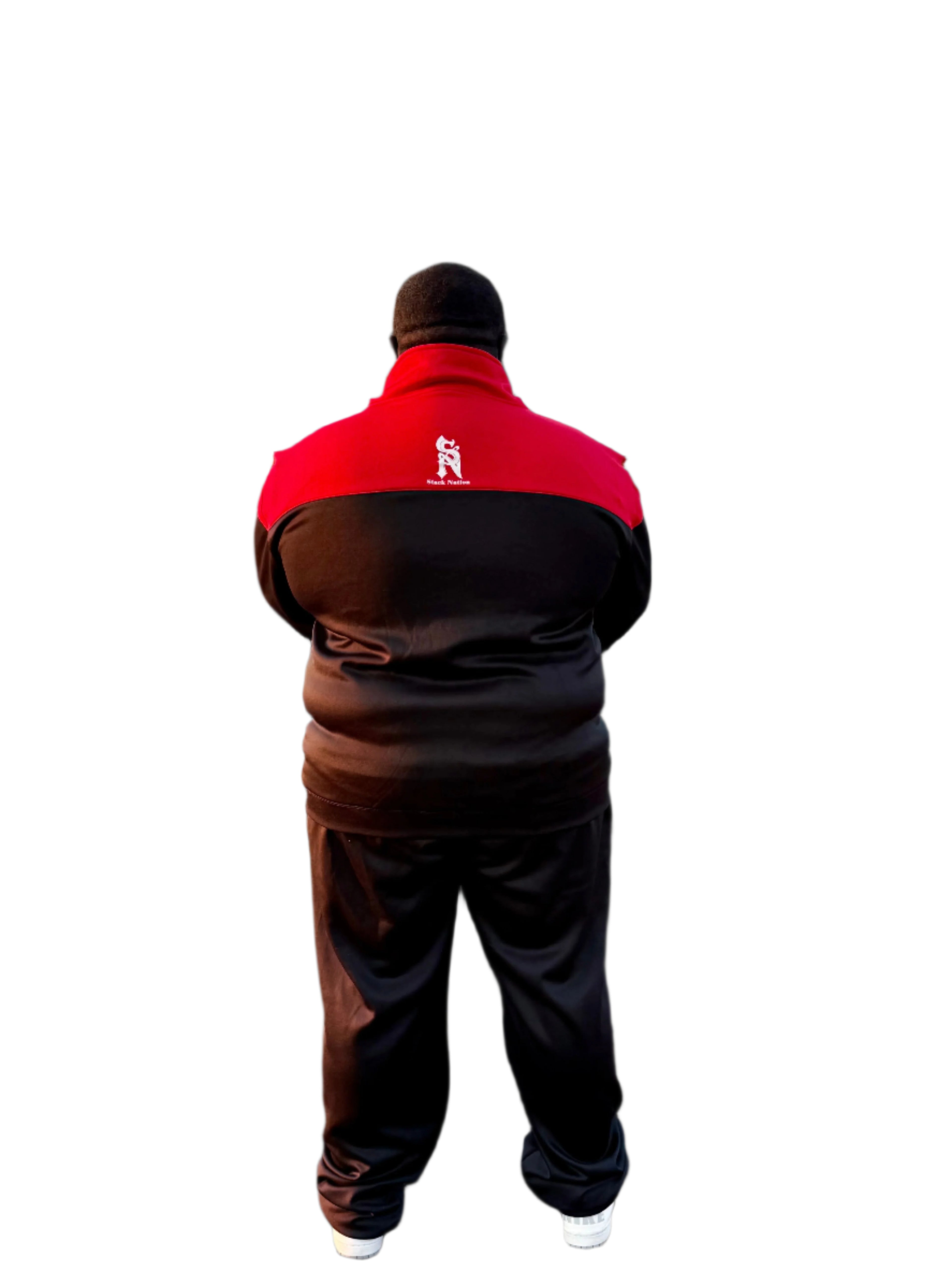 Person wearing a red and black jacket with a logo, standing outdoors on a paved area.