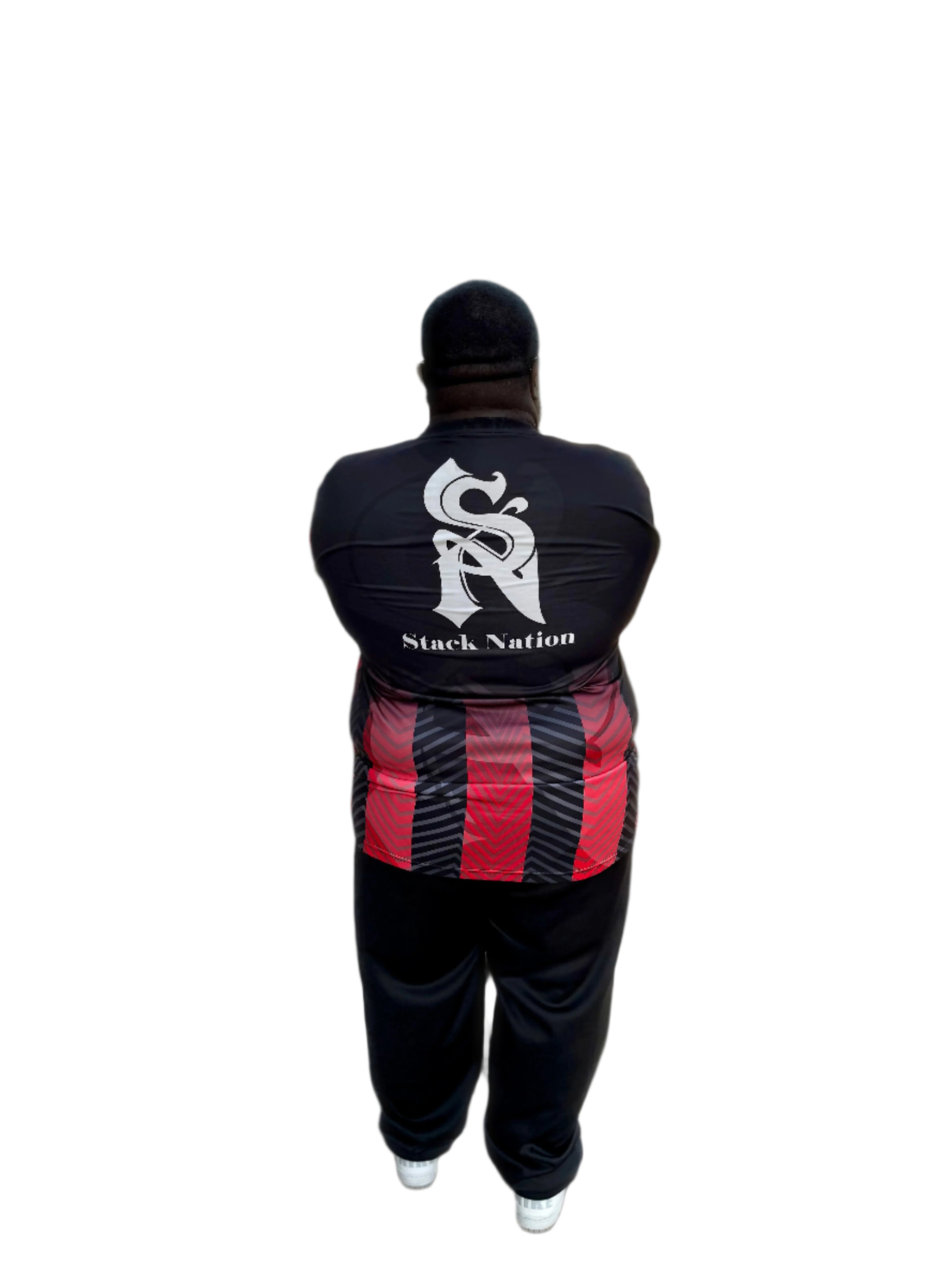 Person wearing a black tracksuit with 'Stack Nation' branding, walking on a street.